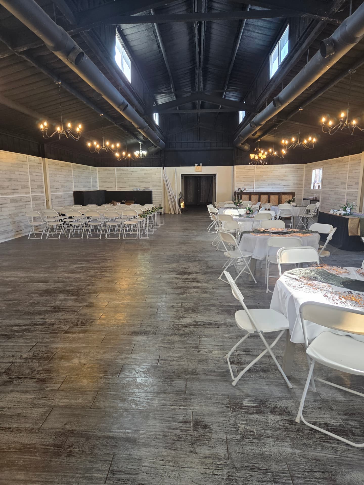 Wide view of the barn interior with dance floor and vaulted black ceiling