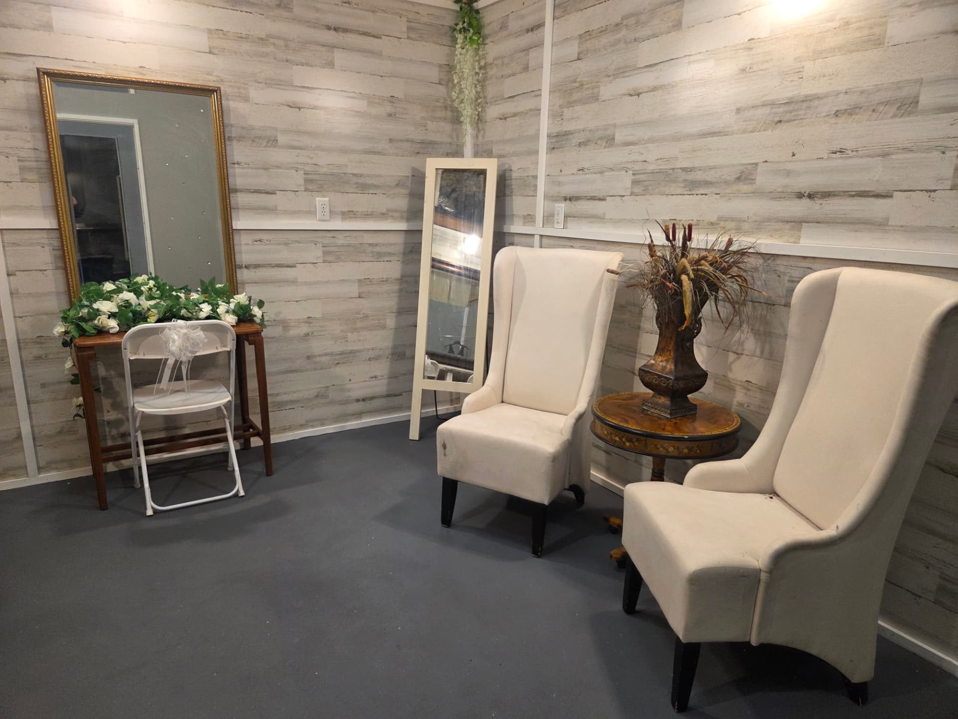 Bridal suite seating area with mirrors, florals and wingback chairs